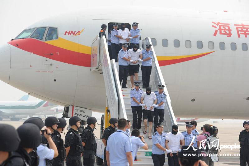 8月25日，被押犯罪嫌疑人走下飞机。（人民网记者 于凯 摄）