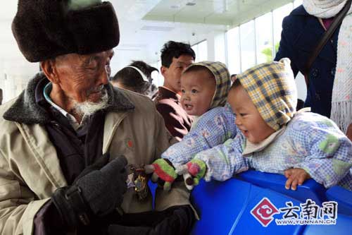 候机时，闫吉安的两个双胞胎重孙对老兵的勋章很感兴趣。